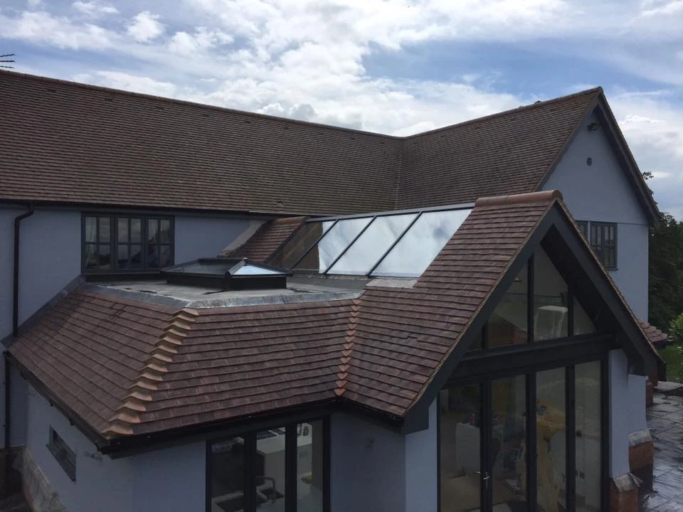 Newly tiled hipped extension roof with roof lantern and glazed rooflight