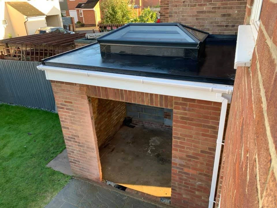 New flat GRP fibreglass roof with roof lantern on a brick home extension