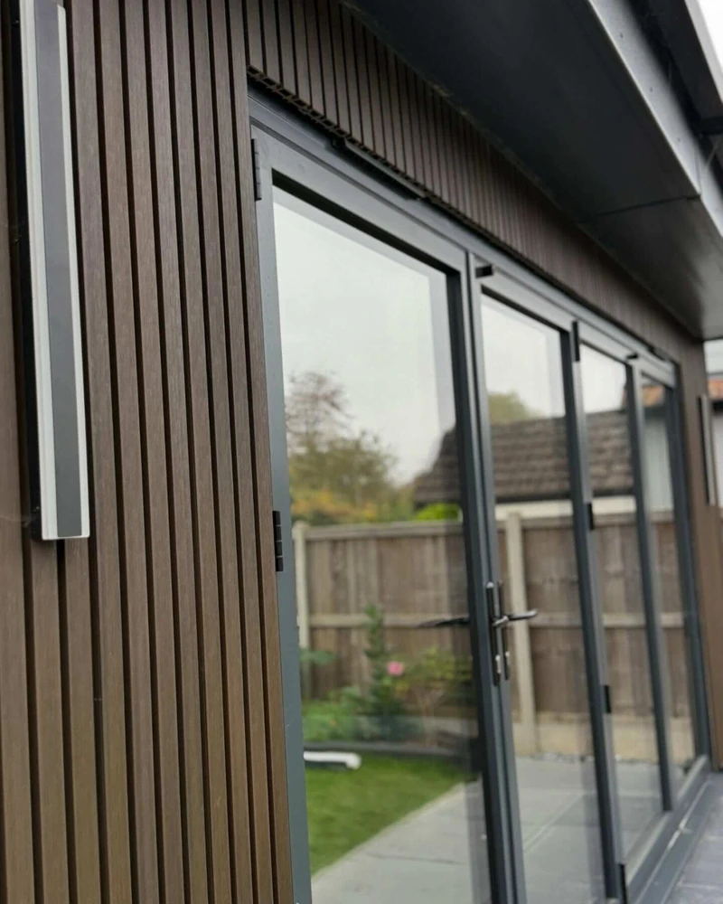 Modern home extension with dark grey fascia, vertical cladding and anthracite bifold doors