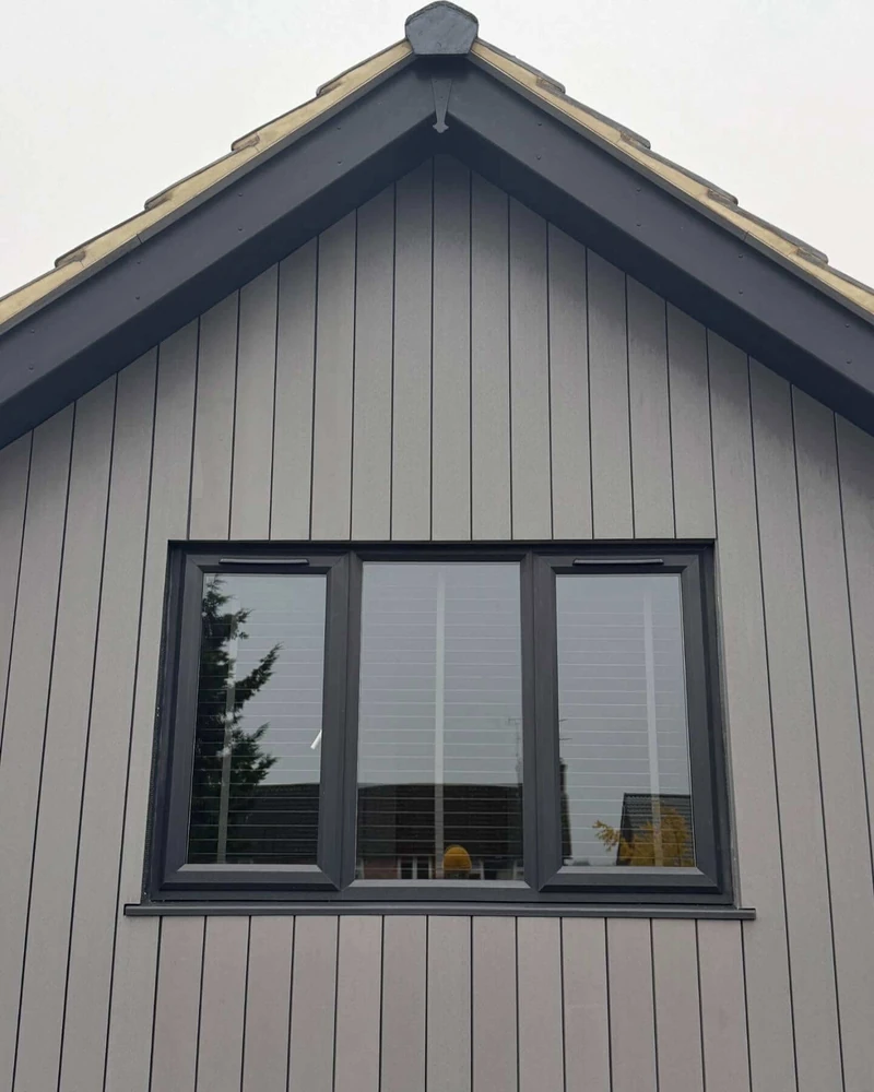 Completed gable roof with ridge tiles and dark grey bargeboards on a modern home