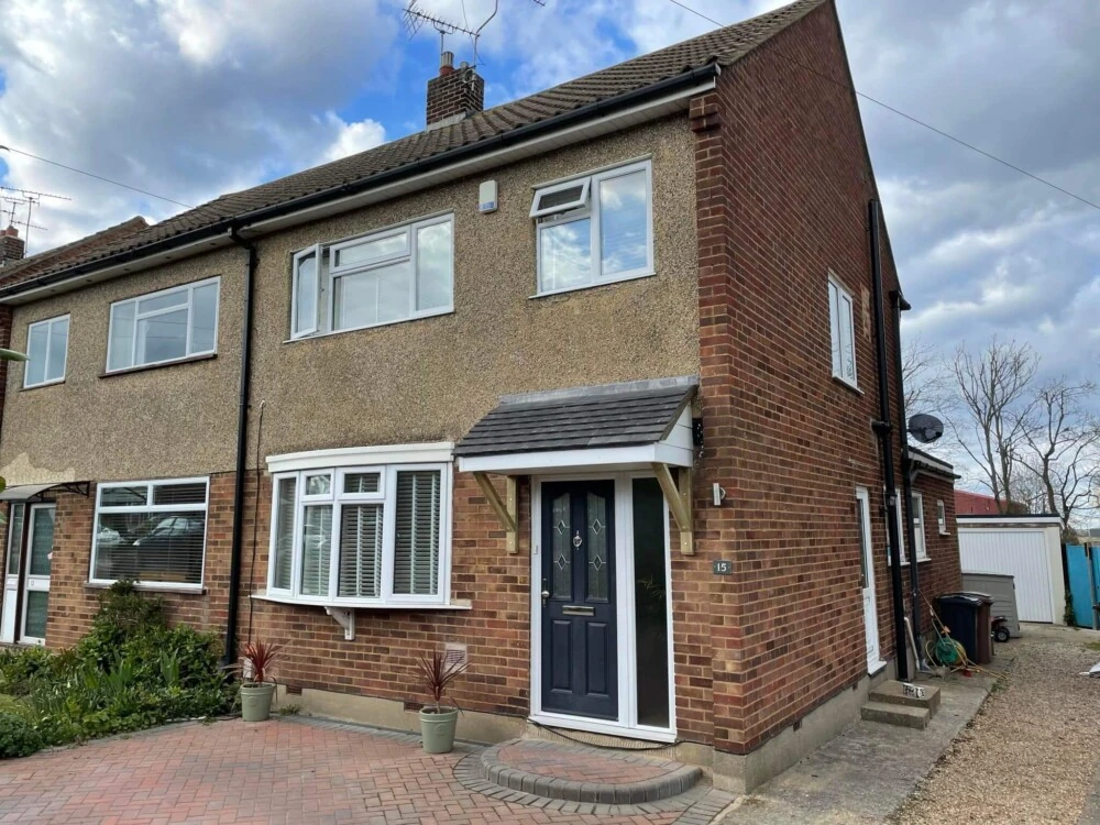 Pitched red-tiled roof on a two-storey brick semi-detached house with chimney